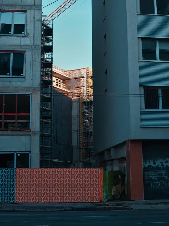 Un chantier de construction moderne entre deux bâtiments dans un cadre urbain.